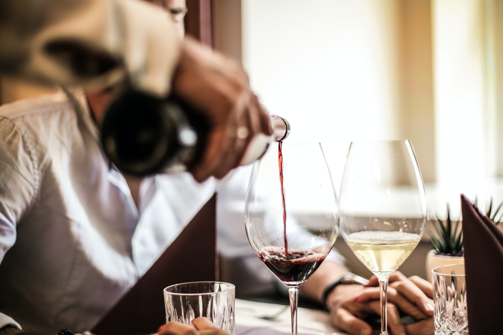 Couple trying white and red wine on holiday in italy